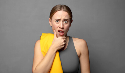 with mouth and eyes wide open and hand on chin, feeling unpleasantly shocked, saying what or wow....