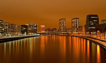 Cityscape at night with river reflections and bridge, ideal for urban backgrounds