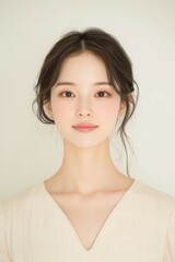 Fototapeta premium Elegant Young Woman in Soft Pastel Dress with Natural Makeup