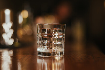 Crystal clear ice cube in a glass on a bar