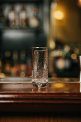 Crystal clear ice cube in a glass on a bar