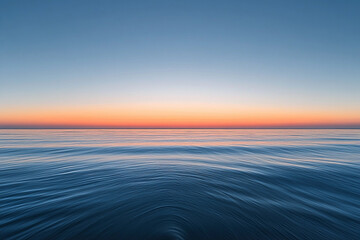 Obraz premium Sunset over calm ocean waters creates a serene atmosphere with vibrant colors on the horizon