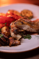Restaurant dish fish with vegetables: zucchini, pepper