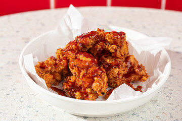 Portion of crispy fried boneless chicken thighs with red sauce