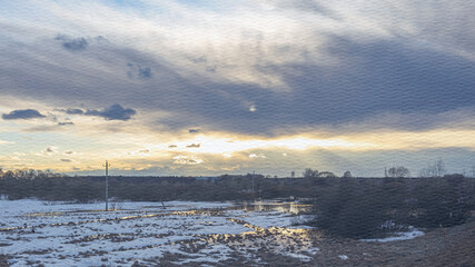 Cloudy sky with a sun setting in the background