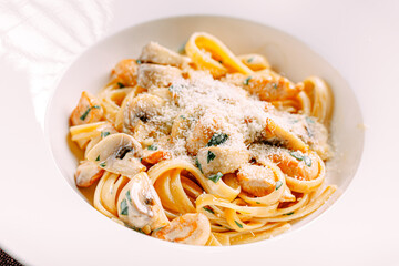 Portion of fettuccine alfredo pasta with mushrooms and chicken