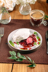 Portion of gourmet Pavlova dessert with berry mousse and jam