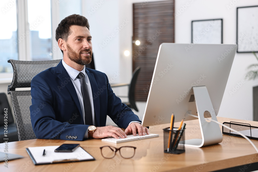 Poster man working on computer at table in office