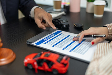 Fototapeta premium Two people are signing a piece of paper that says insurance. Scene is serious and professional