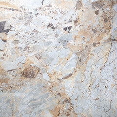 The close-up texture of marble in gray-beige tones with soft veins and color transitions
