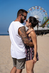 Close-up of young couple looking at each other closely and embracing on the beach in Santa Monica, California.