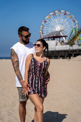 Close-up of loving couple of tourists on Santa Monica beach wearing sunglasses
