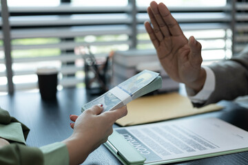 A man and a woman are sitting at a table with a judge. The man is handing the woman a piece of paper

