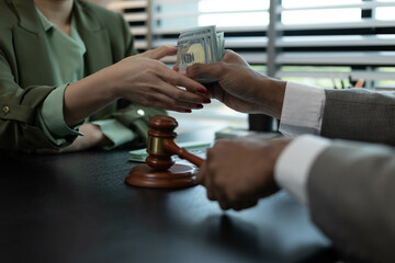 A man and a woman are sitting at a table with a judge. The man is handing the woman a piece of paper
