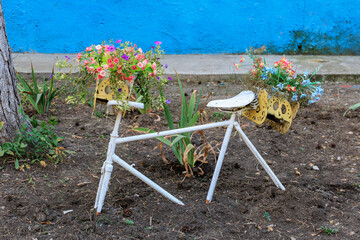 Creative bicycle planter with colorful flowers against blue wall