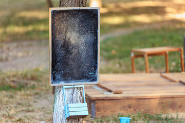 Rustic outdoor chalkboard on tree with wooden background