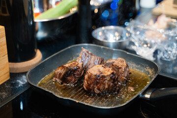 small pieces of beef steak are fried in a frying pan