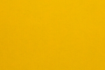 A yellow background with a white object in the middle, textured origami paper backdrop