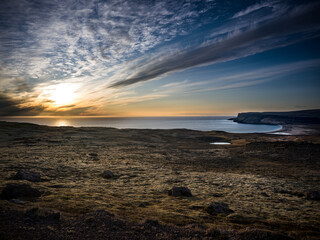 Obraz premium Coucher de soleil sur la côte islandaise, lumière dorée sur un paysage sauvage