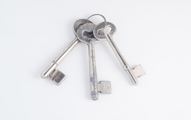 Three old keys with clipping path on white background. Chromed steel keys.