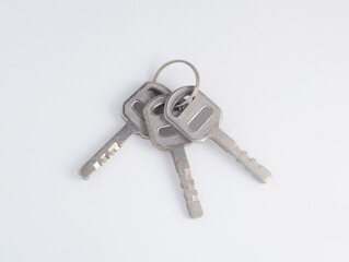 Three steel padlock keys on white background.