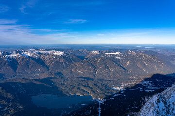Stunning aerial panorama view of Eibsee lake and Ammergau alps in Ammergebirge from top of Zugspitze on a sunny day with blue sky and cloud in winter, Garmisch-Partenkirchen, Bavaria, Germany