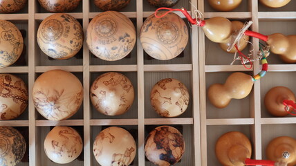 A captivating display of hand-painted wooden or ceramic spheres arranged in a grid in a Chinese...