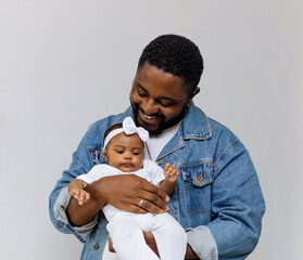 A happy young black father having moments of affection and care with his newborn daughter. Rio de...