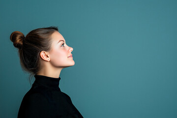 Fototapeta premium portrait of normal woman with black shirt and hair tied on head, posing, side profile view