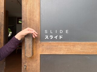 Hand holding a sliding door handle is marked 