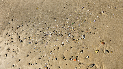 And the background of sand and pebbles with natural relief patterns created will be the wind. Golden sea sand texture, grainy surface.