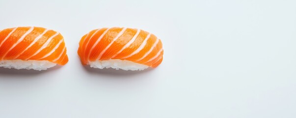 Obraz premium Two pieces of fresh salmon nigiri sushi with perfectly sliced fish and fluffy white rice, isolated on a clean white background