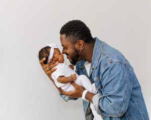 A happy young black father having moments of affection and care with his newborn daughter. Rio de...