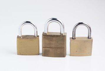 Three mall old solid brass padlocks, isolated on white.