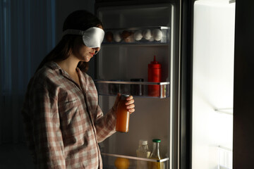 Young woman suffering from sleepwalking near fridge at home