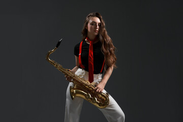 Professional musician with saxophone on grey background