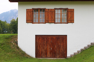 Facciata di casa di montagna con finestre e portone in legno e pareidolia di faccia astratta