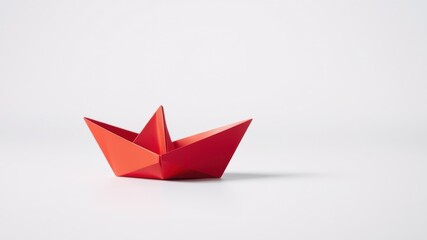 A vibrant red origami boat on a minimalist white background, symbolizing hope, journey, and new beginnings