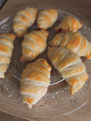 Golden croissants on glass plate, presenting romantic valentine's morning breakfast treat with delicate layers