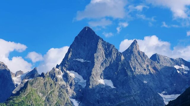 Teberdinsky Nature Reserve. View of Kosygin's glade in the Gonachkhir gorge and the top of Dombai-Ulgen mountain near Lake Tumanly-Kel on a sunny summer day. Panoramic landscape. Resort. 4K