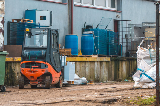 production plant and equipment. forklift, blue barrels, big bags and garbage on the factory ramp.