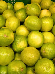 Lime on the counter at the market. Sale of citrus fruits. Healthy food, vitamins and juice. Background, a pattern of a group of fruits, limes. Green fruit. Limes, lemons and oranges