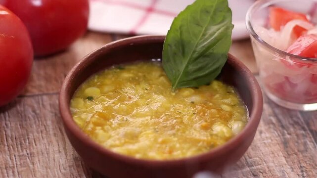Porotos granados con choclo, plato t&iacute;pico de la comida chilena en verano, servido en plato de greda junto a un tomate y ensalda de tomate con cebolla