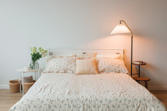 Bedroom interior with bedside tables and an illuminated lamp next to a double bed