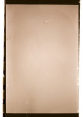 A blank vintage film negative frame with perforations on the sides, featuring a sepia-toned texture and slight scratches, resembling old analog photography materials.