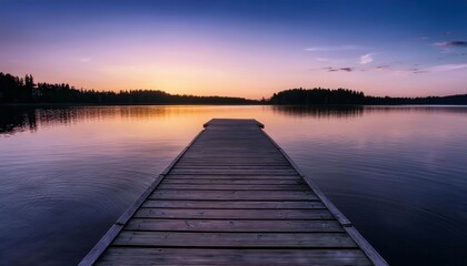 Fototapeta premium Serene sunset reflecting on calm waters from a wooden dock in summer