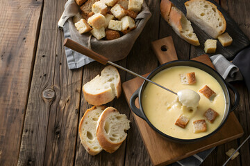 Fototapeta premium Creamy Cheese Fondue Served with Bread and Croutons on Wooden Table