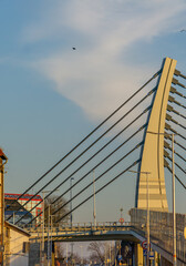 construction of a steel bridge over the road and railway tracks. metal bridge arch. modern structures in the city, architecture against the beautiful sky.
