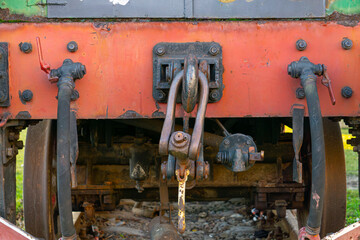an old historic coal-fired steam locomotive standing as an exhibit at the railway station. rusty metal. train couplers