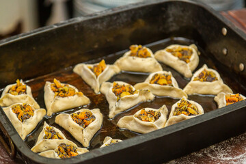 Sweet pastries triangular gomentashi ears of Haman for the holiday of Purim on a baking sheet